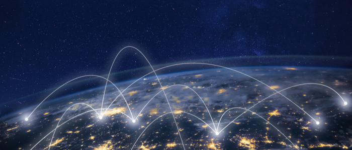 Earth viewed from space at night with glowing city lights and bright arcs connecting locations across the globe.