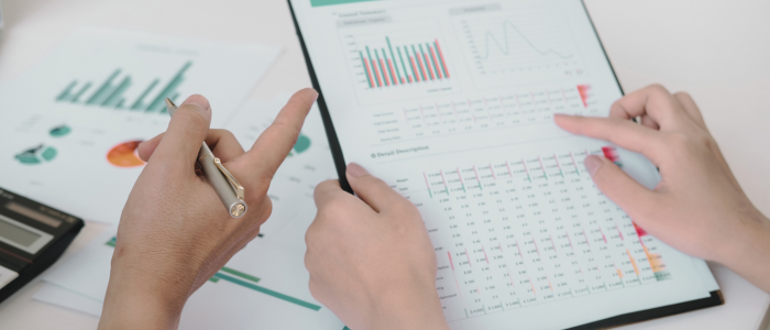 Two people review charts and graphs on printed data reports. To represent that new guidance enhances usability of HMA-EMA real-world data Catalogues.