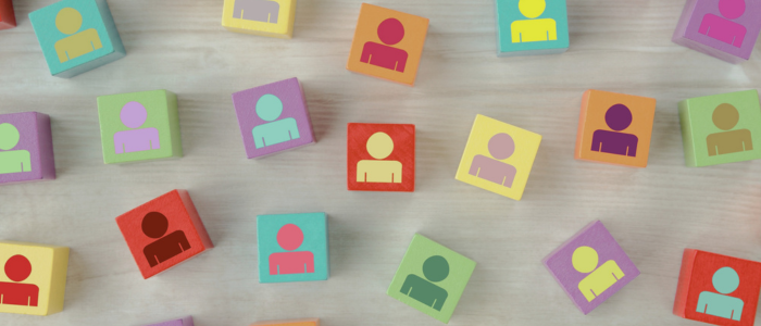 Colorful square blocks with person icons scattered on wooden surface