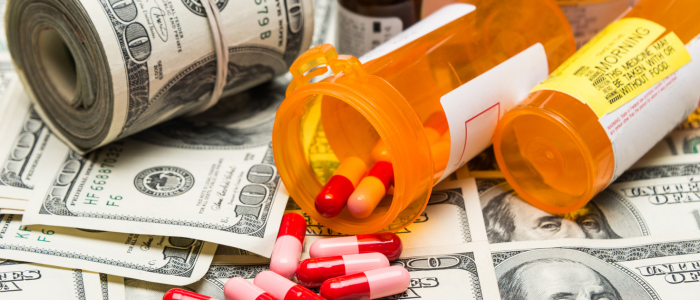 Spilled prescription pills from orange bottles on US dollar bills