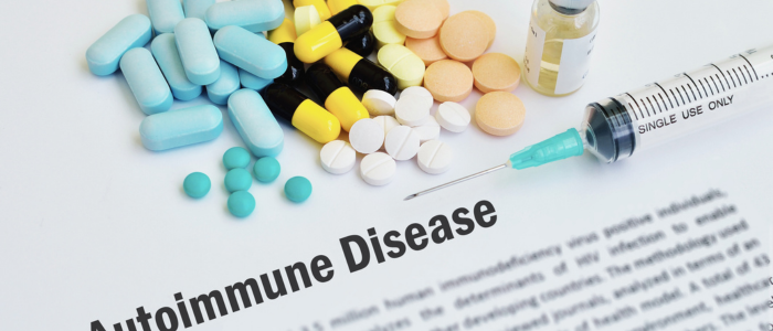 A document labelled 'Autoimmune Disease' with colorful pills, a syringe, and a medicine vial on top.