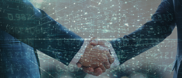 Two businesspeople shake hands with digital data overlay.