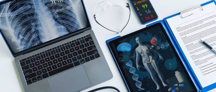 Digital health tools showcasing AI integration with electronic health records, including a laptop, tablet displaying a human anatomy diagram, and medical monitoring devices.