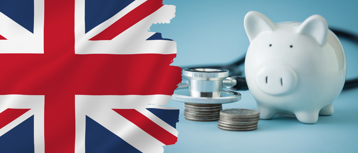 UK flag beside piggy bank, coins, and stethoscope on blue background.