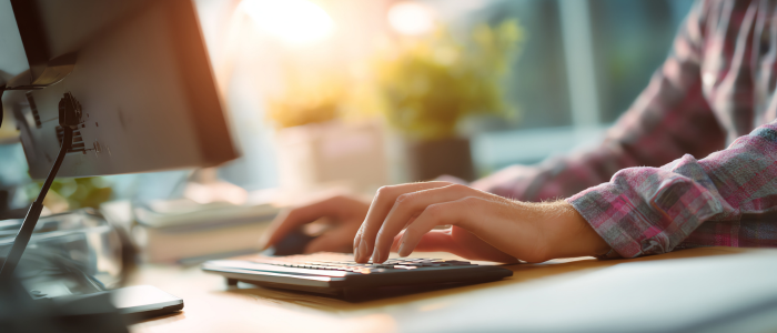 Person typing on a keyboard at a desk, representing the documentation of patient, carer and clinician input in EU Joint Clinical Assessments.