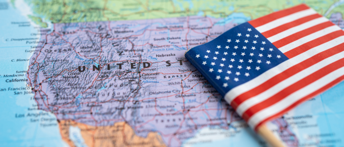 Map of the USA overlaid with the US flag, illustrating the article’s discussion of the CMS GENEROUS Medicaid MFN model