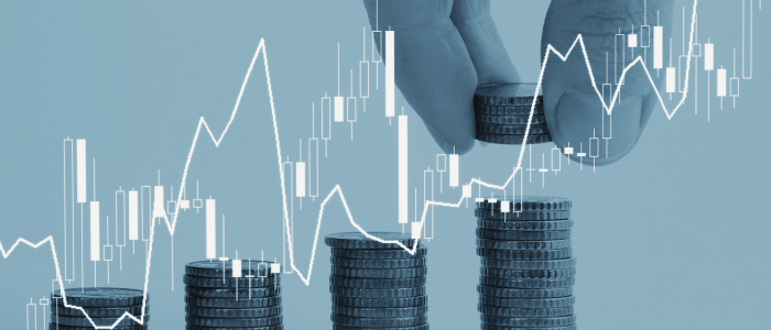 Hand stacks coins beside rising financial chart overlay.