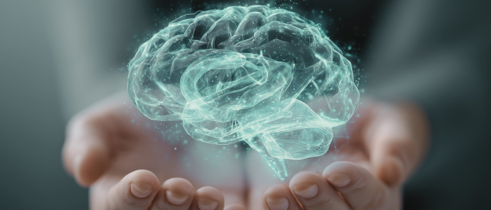 Hands hold a glowing, translucent brain illustration against a dark background.