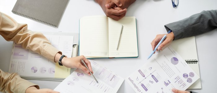 Business professionals gathered around a table with documents and pens, representing Joint Scientific Consultations by the European Commissio