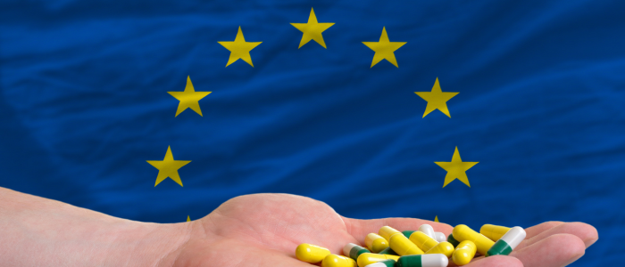 A hand holding a European Union flag, symbolizing European collaboration and policy decisions