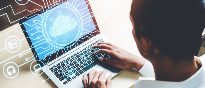 Person uses laptop with digital overlay of cloud computing and data icons.